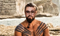 a man with a beard and tattoos on his chest